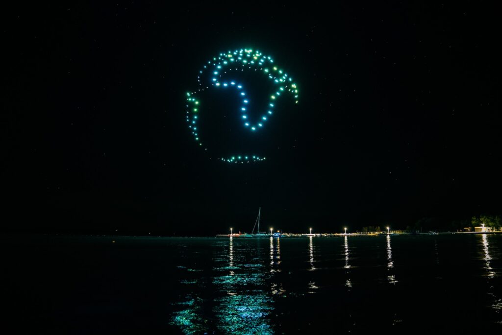 Skydance Drone Light Shows Earth globe drone formation above sea at night with glowing lights