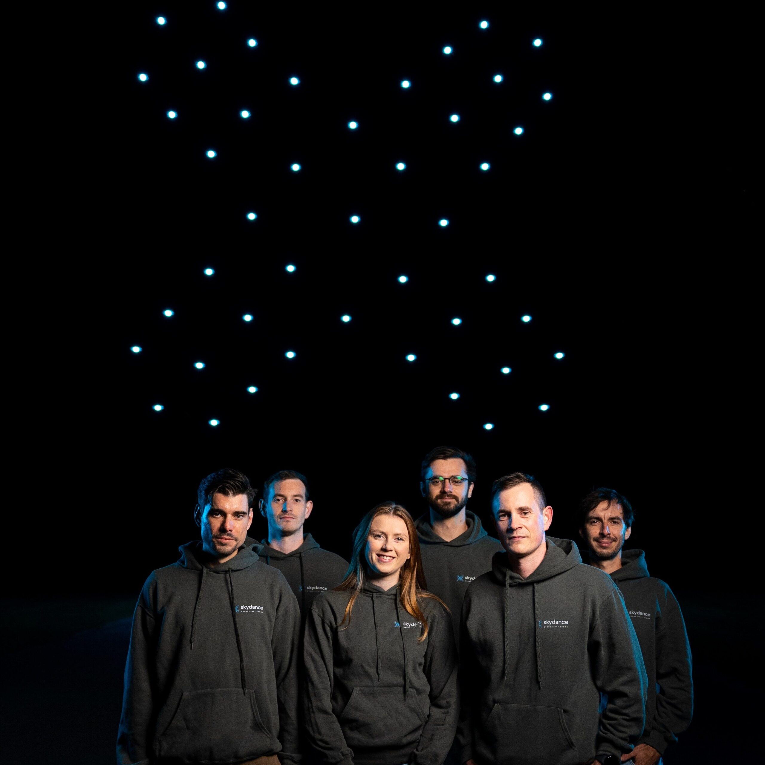 Skydance Drone Light Shows team standing together with drone lights formation in background
