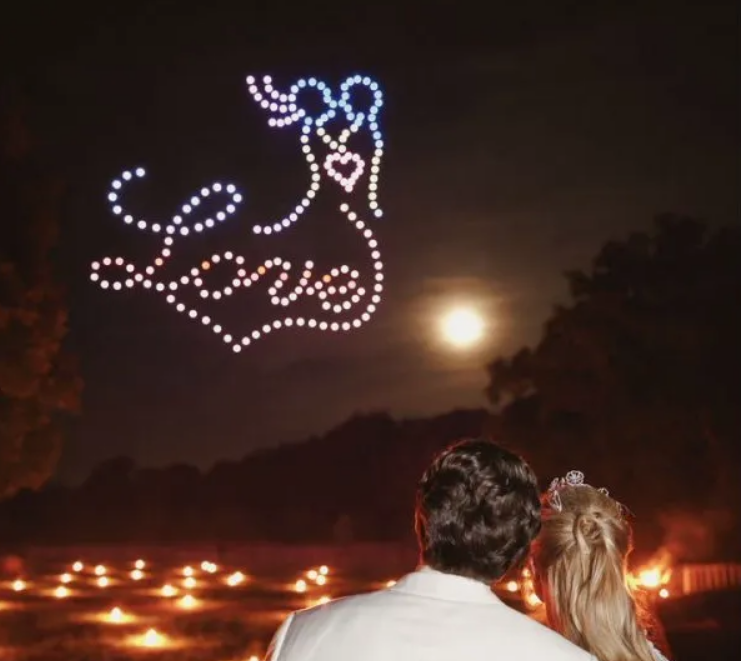 Skydance Drone Light Shows love message with couple drone formation in night sky above romantic scene