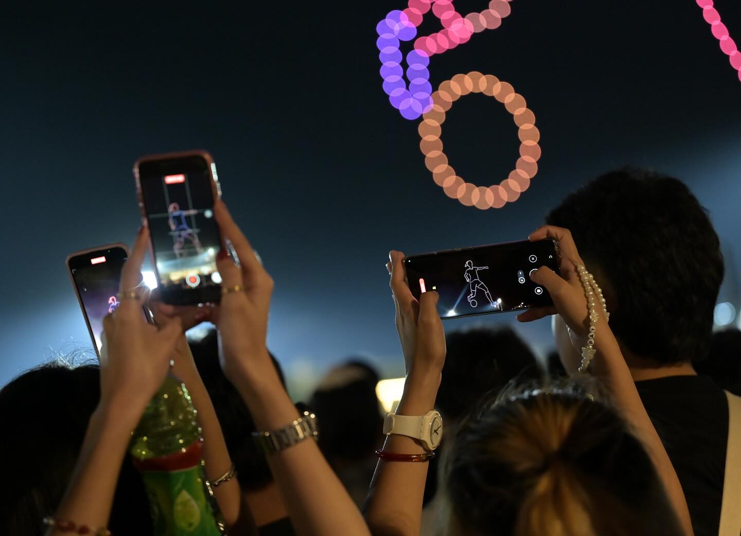 Skydance drone light shows with audience holding phones during nighttime performance